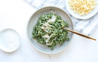 Zusehen sind selbstgemachte Käse-Spinat-Spätzle serviert auf einem weißen Teller