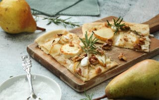Hier sieht man einen vegetarischer Flammkuchen mit Ziegenkäse und Birne