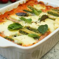 Auf dem Bild ist ein vegetarischer Maultaschenauflauf mit Tomatensoße und Gemüse