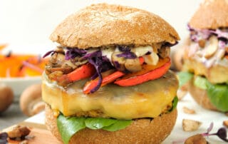 Zusehen ist ein vegetarischer Burger mit Tofu Bratling auf einem Holzbrett