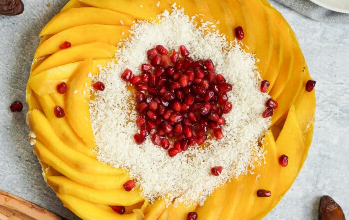 Zusehen ist eine vegane Rohkost Torte mit Mango und Granatapfelkernen