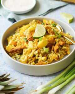 Das Bild zeigt einen Reissalat mit Curry und Ananas|Auf dem Bild ist ein Reissalat mit Ananas und Curry zusehen|Zusehen ist eine Reissalat mit Ananas und Curry