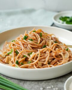 Auf dem Bild ist ein weißer Teller mit einer Portion Spaghetti Carbonara und Räuchertoffu zusehen|Gezeigt wird ein dekorierter Tisch auf dem ein Teller mit Spaghetti Carbonara und Rauchertofu steht|Zusehen ist ein Teller mit Spaghetti Carbonara und Räuchertofu|Zusehen ist eine vegane Spaghetti Carbonara mit Räuchertofu