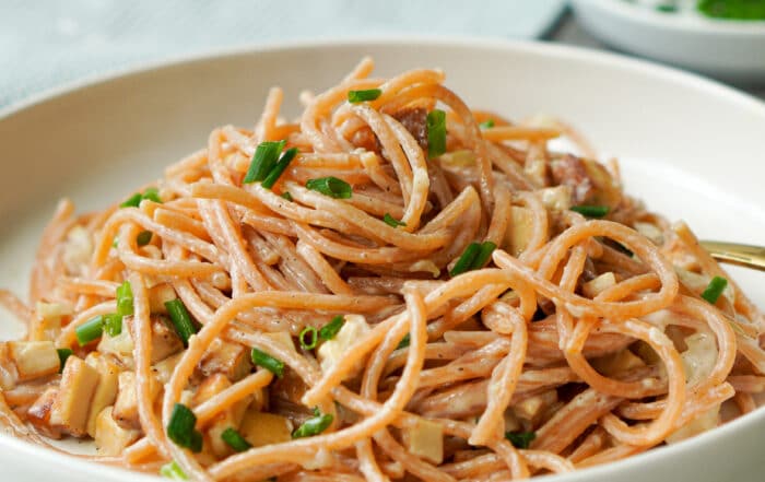 Auf dem Bild ist ein weißer Teller mit einer Portion Spaghetti Carbonara und Räuchertoffu zusehen