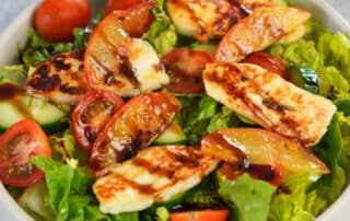 Gezeigt wird ein Halloumi Salat mit karamellisierten Nektarinen und Tomaten